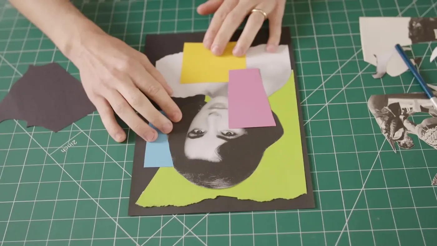 Hands arranging cut paper shapes on a cutting mat